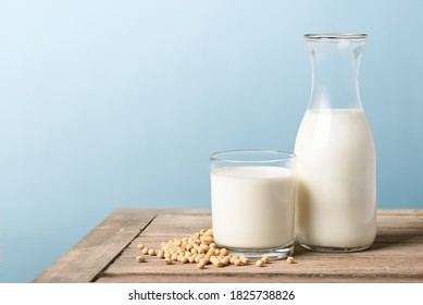 Glass of soy milk with bottle and soybeans on wooden table. - Shutterstock ID 1825738826