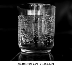 Glass Of Sparkling Water With Black Back Drop 