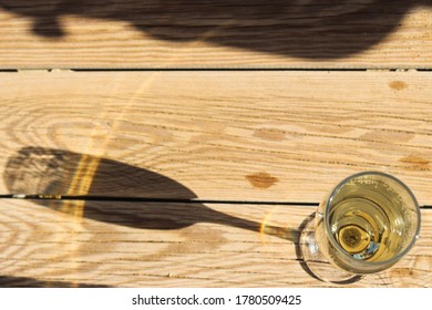 Glass Of Sparkling Wine / Champagne With Long Shadow On A Wooden Background. Top View. Copy Space, Soft Focus.