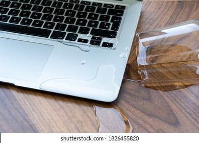 Glass of spilled water on laptop	
