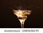 glass with splashes of champagne from cherry berries on a dark b