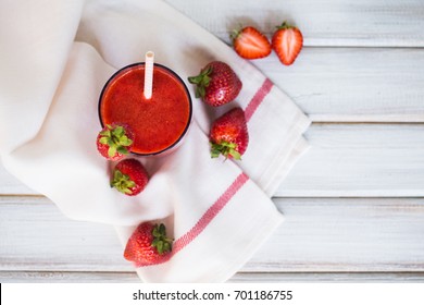 A Glass Of Strawberry Smoothie On A White Wooden Background