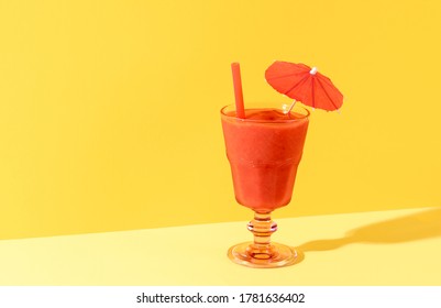 Glass Of Strawberry Smoothie With Straw Isolated On Duotone Yellow Background. Strawberry Cocktail With Umbrella. Summer Drink. Homemade Berry Granita