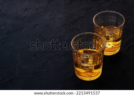Glass of strong alcoholic drink whiskey with ice. Alcohol background