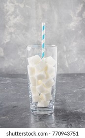 Glass With Sugar Cubes Is An Unhealthy Diet. The Contents Of Sugar In Sweet Soda