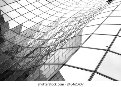 Glass surface of skyscrapers view in district of business centers with reflection on it, black and white 