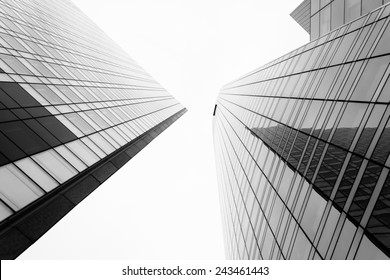 Glass surface of skyscrapers view in district of business centers with reflection on it, black and white 