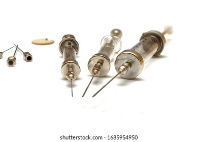 Glass Syringes And Needles Of The 20th Century. White Background. Close-up