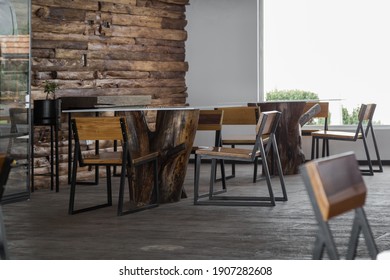 Glass Table With A Log In The Center, Metal Tables With Wood Inside A Coffee Shop With A Window