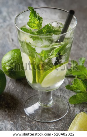 Glass tank mojito and Ingredients for cocktails. Fresh mint, limes, sugar over black backdrop. copy space