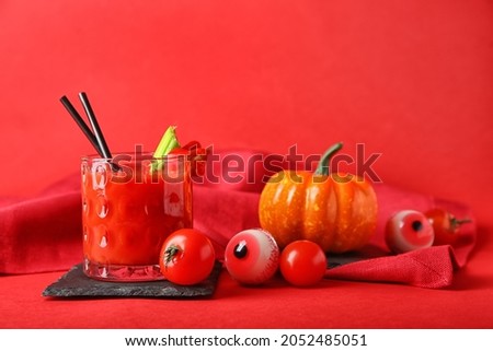 Glass of tasty bloody Mary cocktail decorated for Halloween on color background