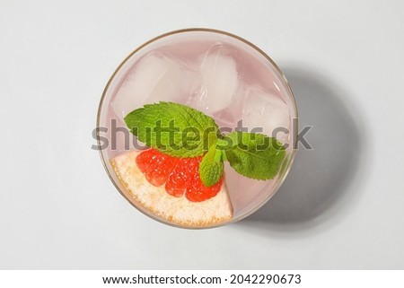 Glass of tasty grapefruit margarita on light background