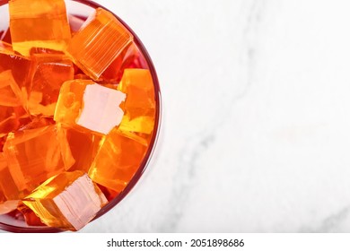 Glass with tasty jelly cubes on white background, closeup - Shutterstock ID 2051898686
