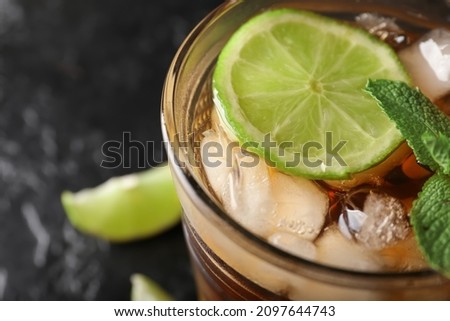Glass of tasty Long Island iced tea on dark background, closeup