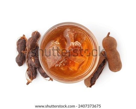 Glass of tasty tamarind drink and fruits on white background
