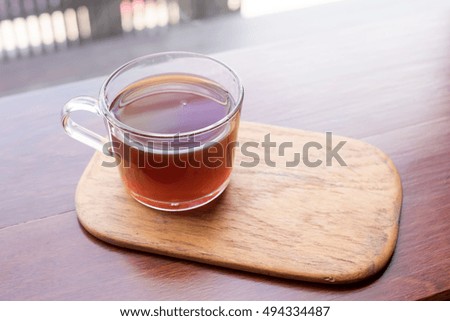 Glass of tea on wooden Coaster in restaurant