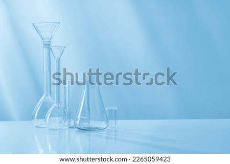 Glass test tubes, various dishes of a chemical laboratory on a light background.