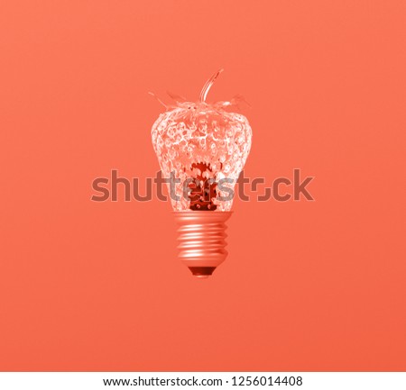 Glass textured strawberry lightbulb idea on creative Leaving Coral background. Concept of color of the year 2019. Minimal idea concept. Trendy pastel colors.