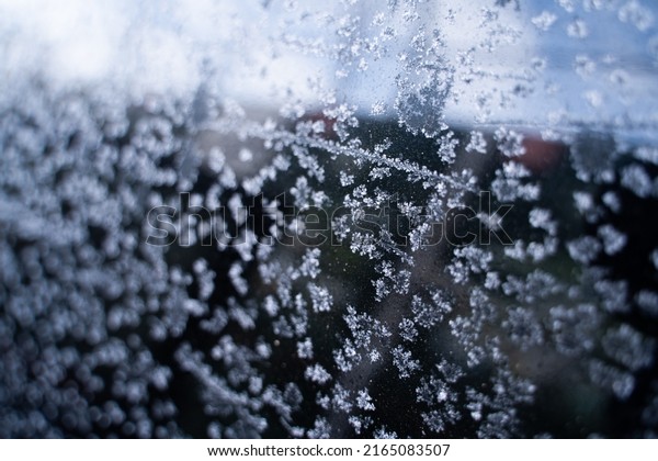 The\
glass of a tinted car is covered with frost\
close-up