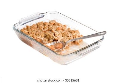 A Glass Tray Filled With Delicious Apple Crisp Ready To Be Served With A Spoon, Isolated Against A White Background