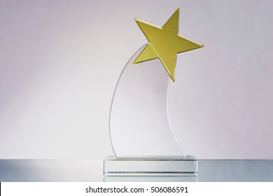 Glass Trophy With Yellow Star In Gray Background - Competition, Award And Wining Concept