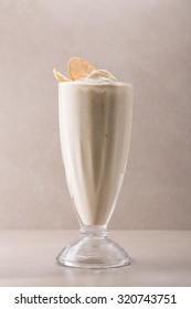 Glass Of Vanilla Milkshake Isolated On Grey Background