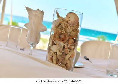 Glass Vase Centerpiece Filled with a Variety of Sea shells for a Beach Wedding Party