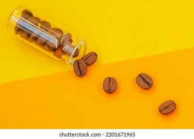 Glass Vial With Coffee Beans Like Pills, Top View. Abstract Bicolor Background. Stimulant Of Energy Concept