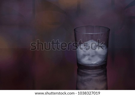 Glass of vodka with ice cubes on a fractal bacground.
