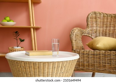 Glass Of Water And Book On Rattan Table In Living Room