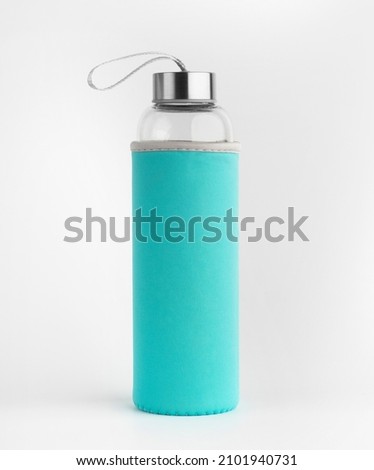 Glass water bottle with green protective case. Isolated on a white background. 