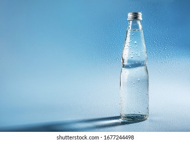 Glass Water Bottle On Blue Background