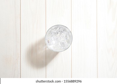 Glass Of Water With Ice On The White Wooden Table, Seen From Above