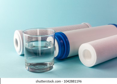A glass of water on the background of filter cartridges