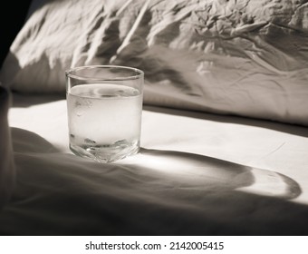 A Glass Of Water On The Bedside In The Hotel Room .