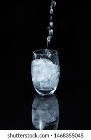 Glass Of Water  On A Black Shinny Floor