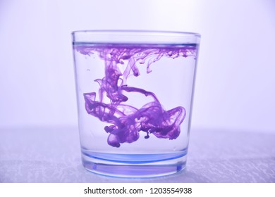 Glass with water on a white background with purple paint. - Powered by Shutterstock