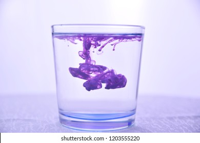 Glass with water on a white background with purple paint. - Powered by Shutterstock