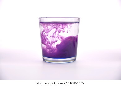 Glass with water on a white background with purple paint. - Powered by Shutterstock