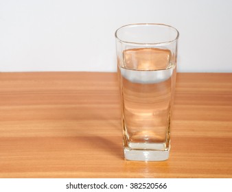 Glass with water on wooden background