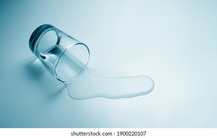 Glass of water spilled, drops of Water spill on a table, light blue background with copy space