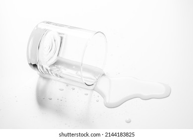 a glass of water spilled on a white table - Shutterstock ID 2144183825