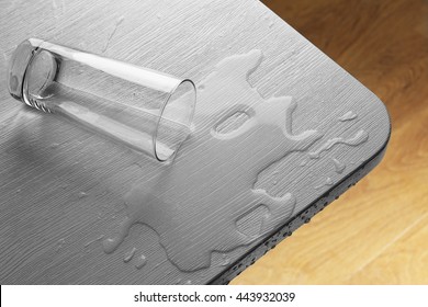 Glass Of Water Spilled On Wooden Table