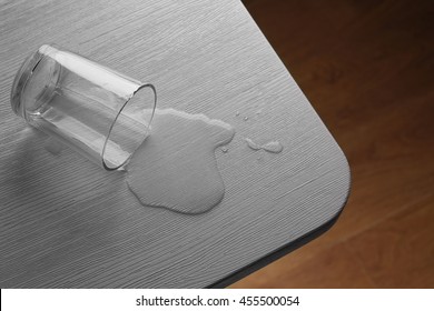 Glass Of Water Spilled On Wooden Table