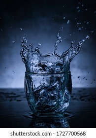 A glass of water splash with blue background.