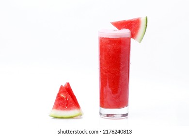a glass of watermelon juice and small pieces of sweet and fresh on a white background