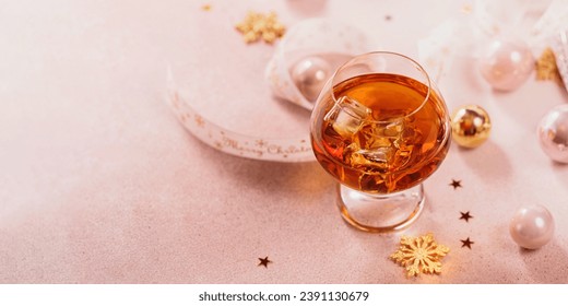 Glass of whiskey or bourbon with festive Christmas decoration on light background. New Year, Christmas and winter holidays whiskey mood concept - Powered by Shutterstock