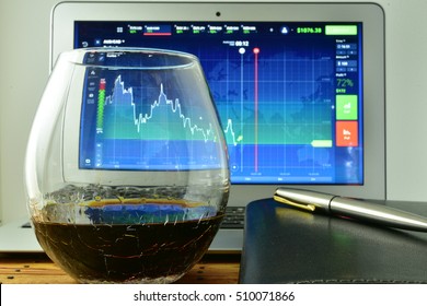 A Glass Of Whiskey In Front Of A Laptop With A Stock Ticker On The Screen