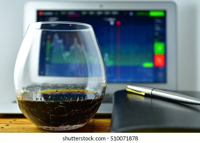 A Glass Of Whiskey In Front Of A Laptop With A Stock Ticker On The Screen