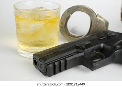 Glass of whiskey and gun.Concept of crime and alcohol relation.